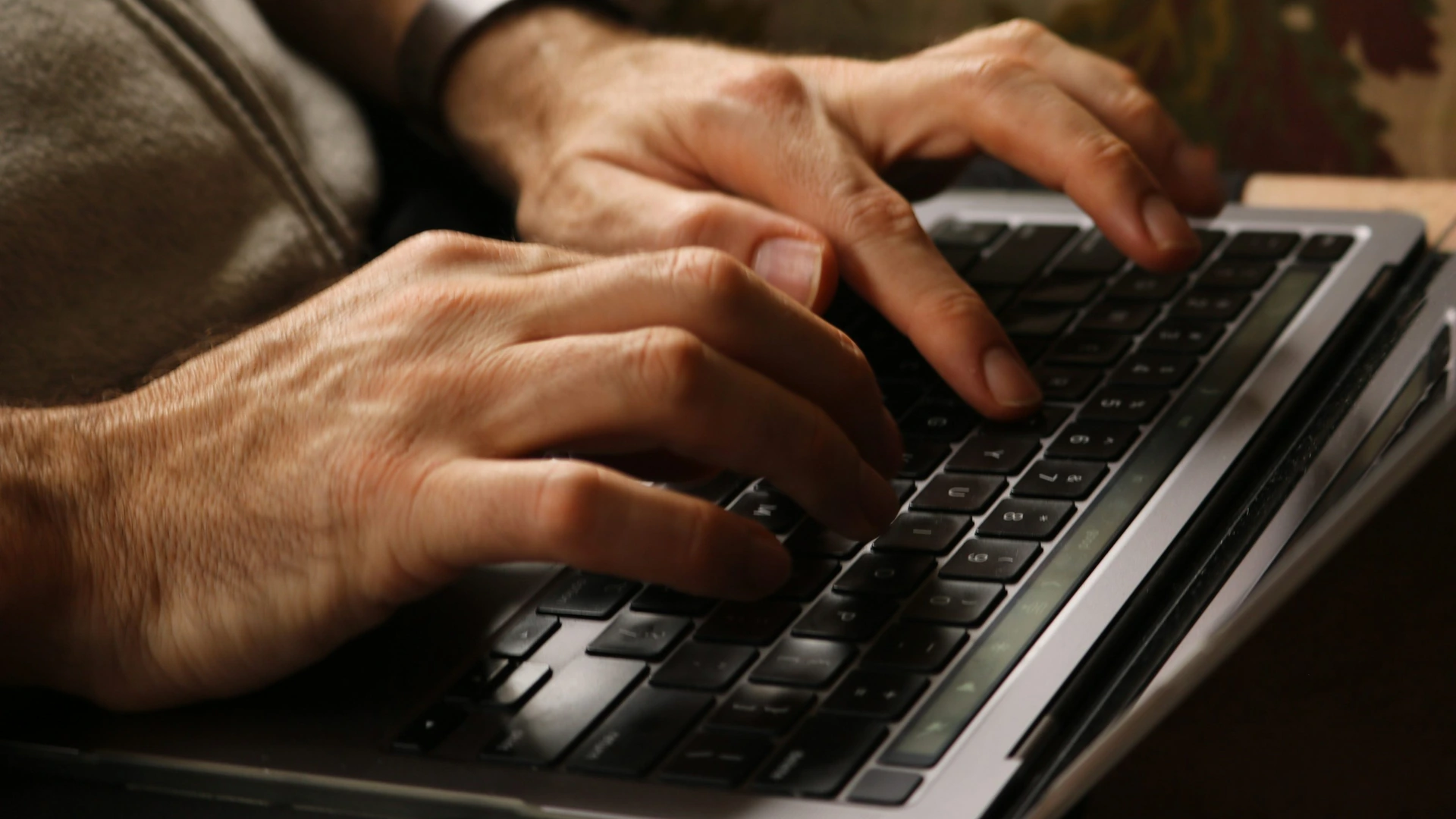 Illustrative photograph of hands typing on a laptop.